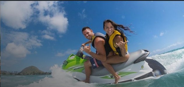 Pareja practicando deportes acuáticos en la playa